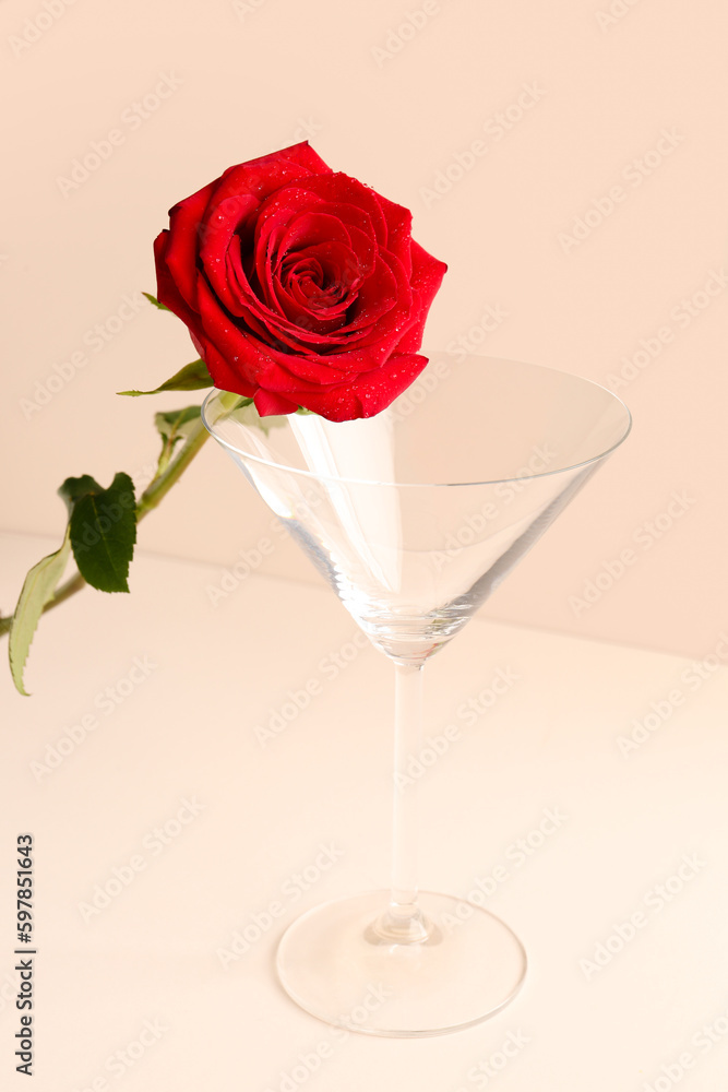 Glass with beautiful red rose on light background Glass with beautiful red rose on light background