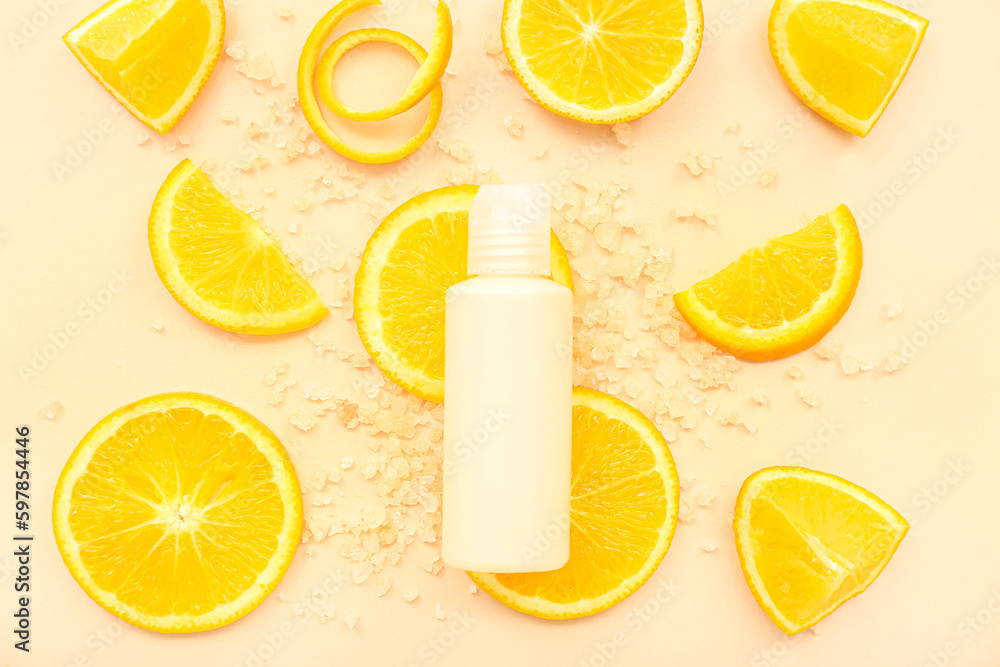 Cosmetic bottle with orange slices and sea salt on beige background Cosmetic bottle with orange slices and sea salt on beige background