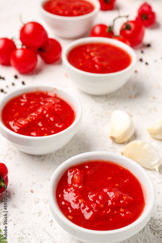 Bowls with tasty tomato sauce on light background Bowls with tasty tomato sauce on light background