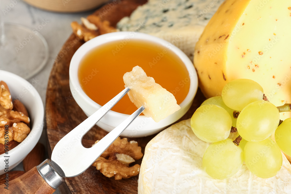Fork with piece of tasty cheese on table, closeup Fork with piece of tasty cheese on table, closeup