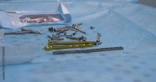Close-up. A set of sterile instruments for osteosynthesis on the table in surgery. In the operating room, there are screws and titanium plates on the table for the treatment of a fracture.