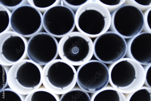 Pile of white and black PVC tubes and pipes abstract background construction site