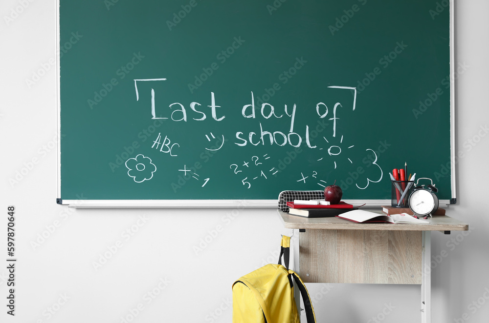 Text LAST DAY OF SCHOOL with drawings on blackboard in classroom Text LAST DAY OF SCHOOL with drawings on blackboard in classroom