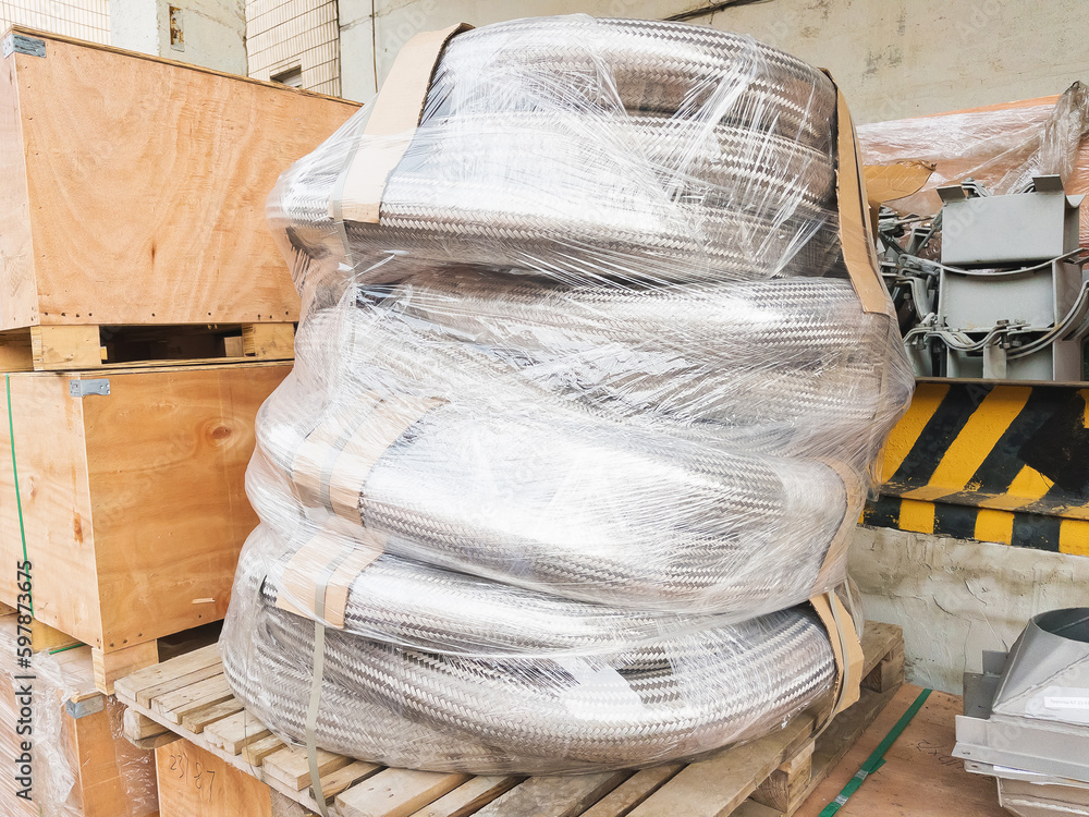 Packed metal hoses (metallic hoses) for transporting substances and media, wrapped in stretch film and ready for shipping.