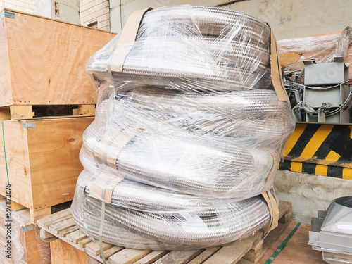Obraz na płótnie Packed metal hoses (metallic hoses) for transporting substances and media, wrapped in stretch film and ready for shipping. w salonie