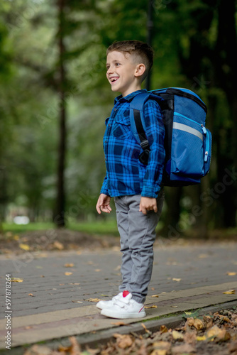 Portrait of a first grader with a backpack. The boy goes to school