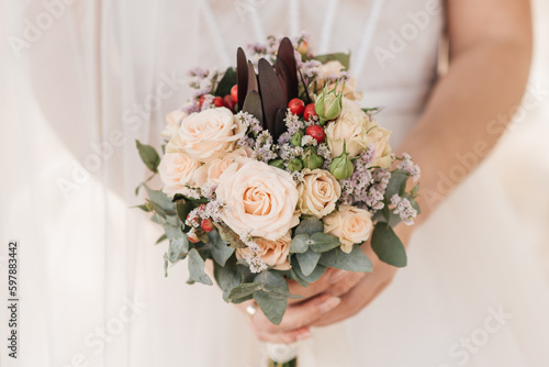 Fototapeta Naklejka Na Ścianę i Meble -  Beautiful wedding bouquet with protea and roses in the hands of the bride