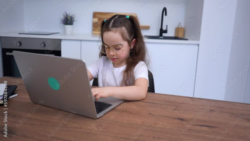 Elementary school girl with glasses talking to teacher online. Distance learning Elementary school girl with glasses talking to teacher online. Distance learning