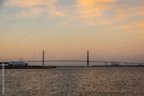 A distant bridge over a large body of water at sunset with