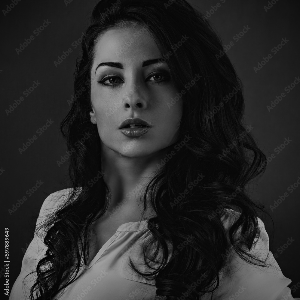 Beautiful emotional woman with bright makeup face and long volume hairstyle. Black and white artist portrait. Closeup