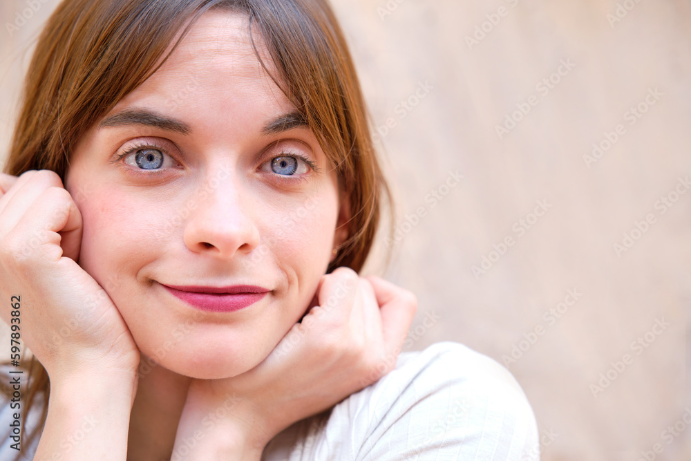 portrait of pretty young girl with blue eyes with hands resting on chin with defocused background portrait of pretty young girl with blue eyes with hands resting on chin with defocused background
