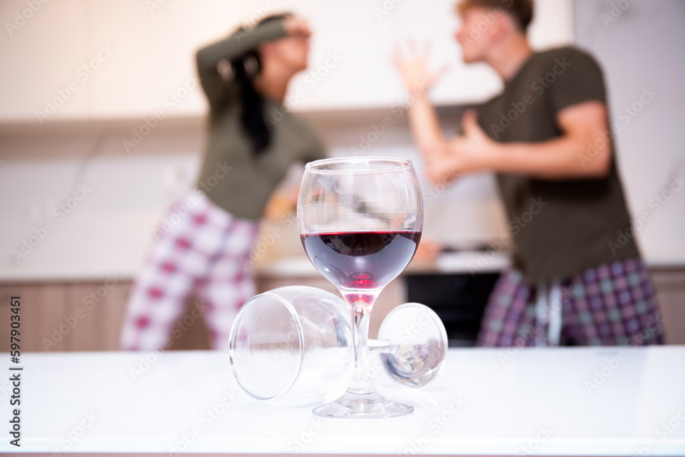 An alcoholic husband quarrels with his wife at home, sitting on the couch An alcoholic husband quarrels with his wife at home, sitting on the couch