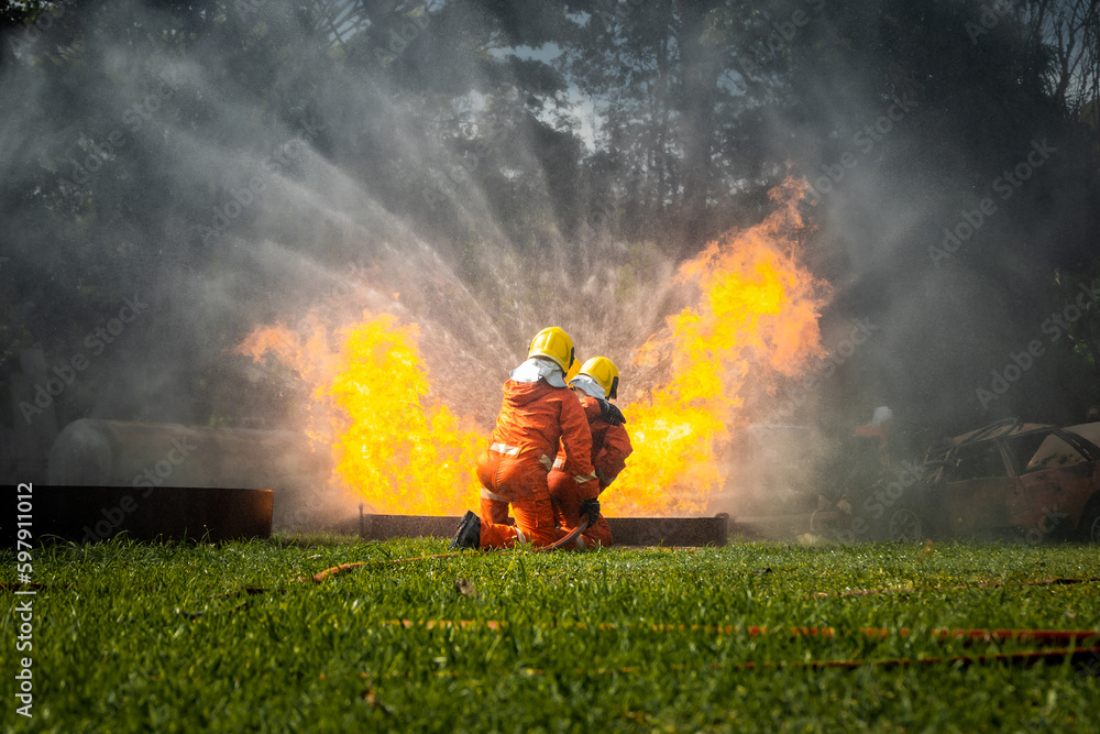 Firefighter Concept. Fireman using water and extinguisher to fighting