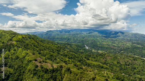 Aerial drone of river in a mountain valley among agricultural land and rice fields. Negros, Philippines