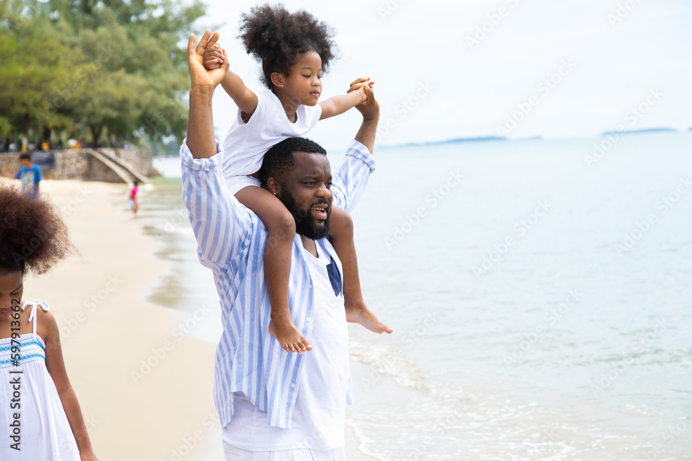 Black family having fun on the beach. mixed race family relaxing at the beach on summer holiday. Daughter in father arms or piggy back. Black family having fun on the beach. mixed race family relaxing at the beach on summer holiday. Daughter in father arms or piggy back.