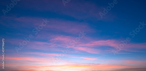 Beautiful Romantic Orange Sunset Clouds with sunlight on Dusk Sky Twilight background in Panoramic view © Prapat