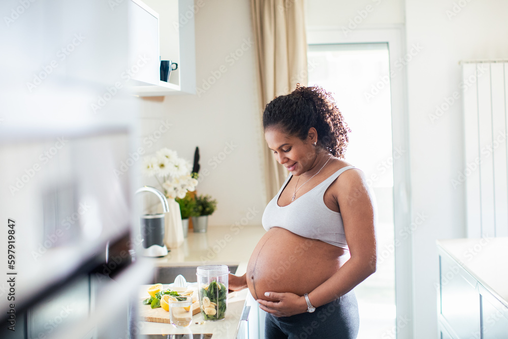 Young pregnant latina woman preparing a salad in the kitchen Young pregnant latina woman preparing a salad in the kitchen