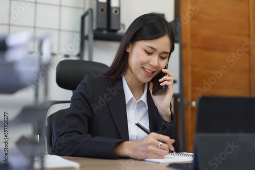 Work of secretary concept, Female secretary talks on phone with boss and taking notes in notebook