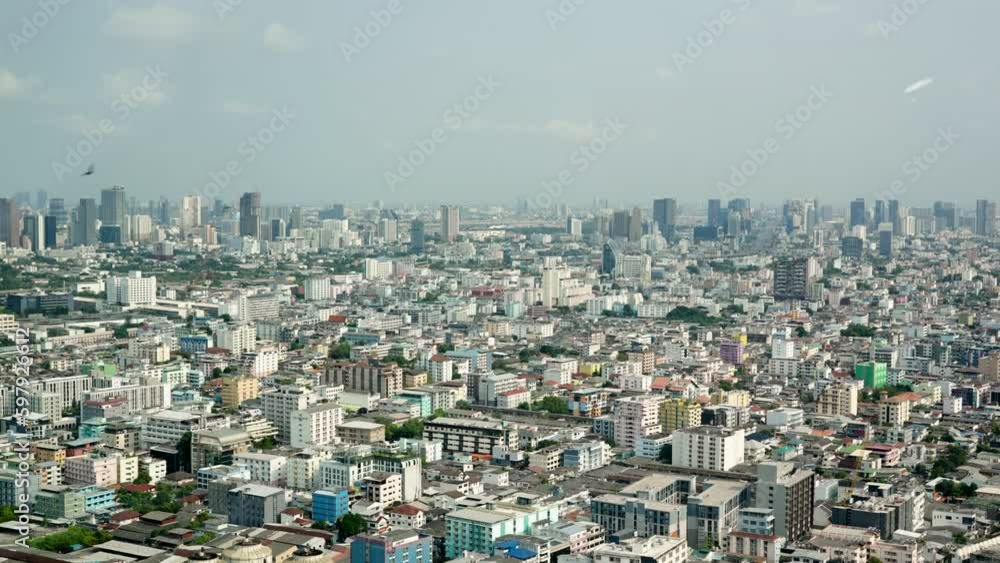 Bird's eye view of Bangkok, Thailand, seen from the top of the building during the day The camera pans from left to right. to see many buildings in big cities on a clear day Bird's eye view of Bangkok, Thailand, seen from the top of the building during the day The camera pans from left to right. to see many buildings in big cities on a clear day