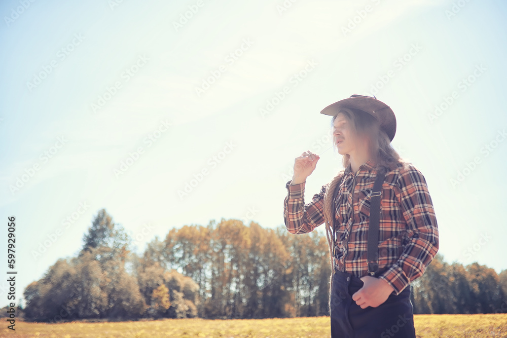 Cowboy with hat in a field in autumn