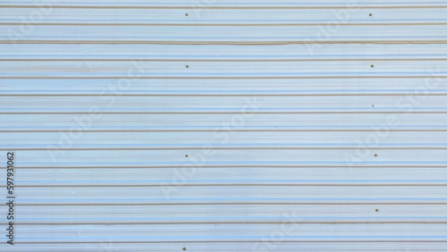 Iron fence. Galvanized corrugated roofing sheet. The texture is made of silver steel corrugated iron.