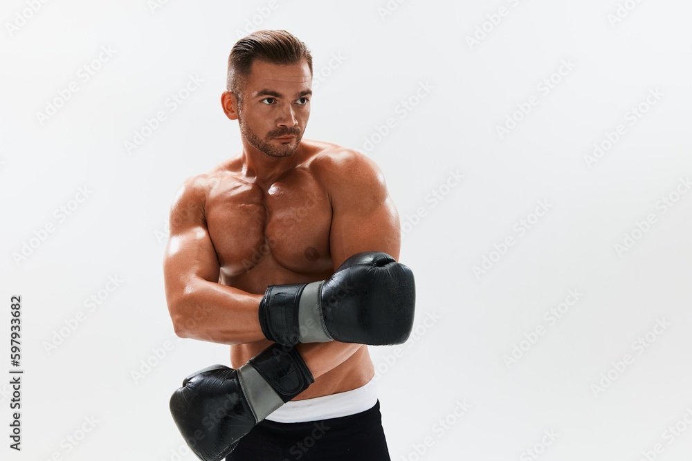 Man athletic bodybuilder poses in boxing gloves with nude torso abs in full-length background, boxing and martial arts. Advertising, sports, active lifestyle, competition, challenge concept. 