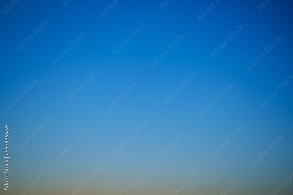 Sunset sky gradient from yellow to blue, copy space. Clear sunset sky with the bright light of the setting sun