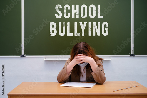 Text is a school bullying on the blackboard and a sad teacher in the classroom. Problems with insults and humiliations of children during education at school