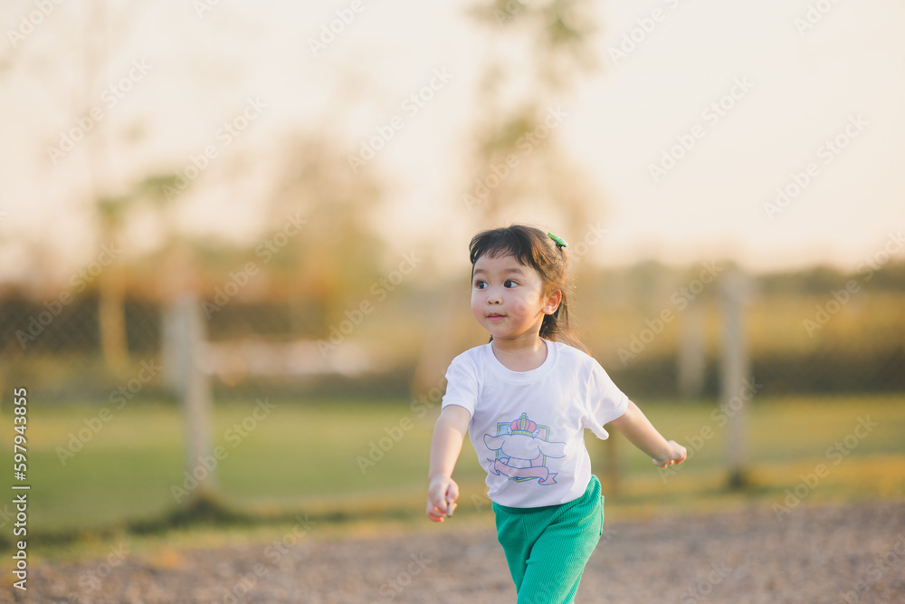 Freedom style of asia baby cute girl Jump play on a the outdoor playground with happy time on evening time Freedom style of asia baby cute girl Jump play on a the outdoor playground with happy time on evening time