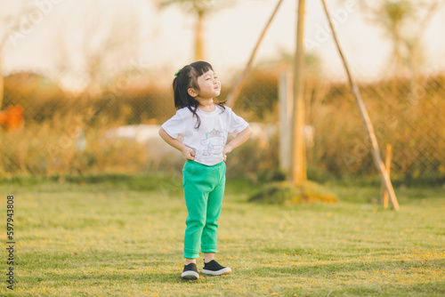 asia baby smile cute girl play on a the outdoor playground with happy time on evening time
