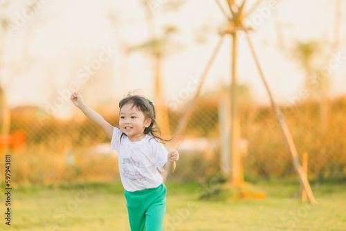 Freedom style of asia baby cute girl run play on a the outdoor playground with happy time on evening time