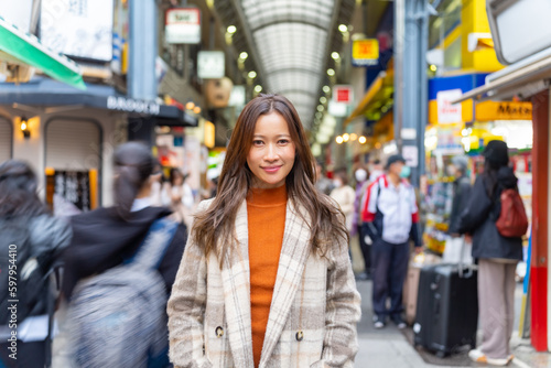 Portrait of Young Asian woman walking and shopping at street market in Tokyo city, Japan in autumn. Attractive girl enjoy and fun urban outdoor lifestyle travel in the city on winter holiday vacation.