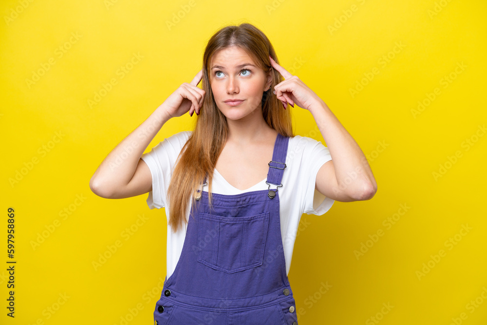 Fototapeta premium Young caucasian woman isolated on yellow background having doubts and thinking