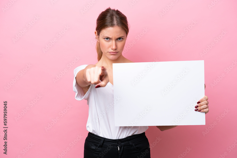 Young caucasian woman isolated on pink background holding an empty placard and pointing to the front Young caucasian woman isolated on pink background holding an empty placard and pointing to the front