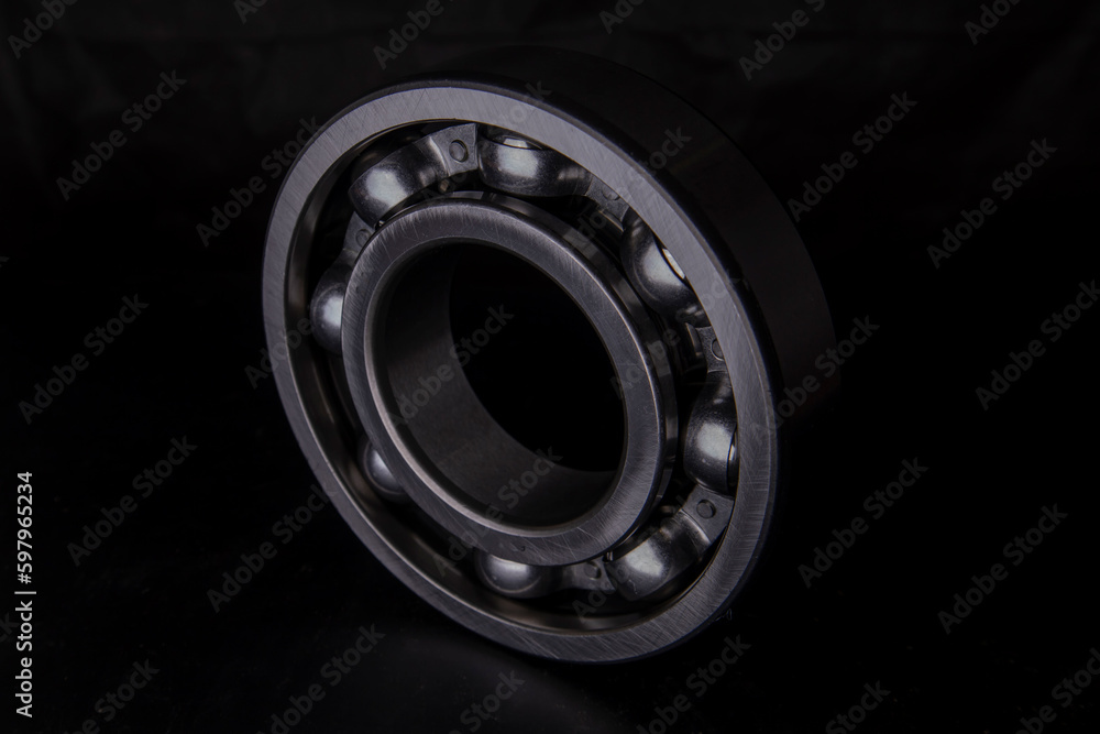 A large bearing in a hand on a dark background A large bearing in a hand on a dark background