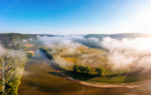 Landscape with a picturesque river flowing through green meadows. Dniester canyon national park, Ukraine, Europe.