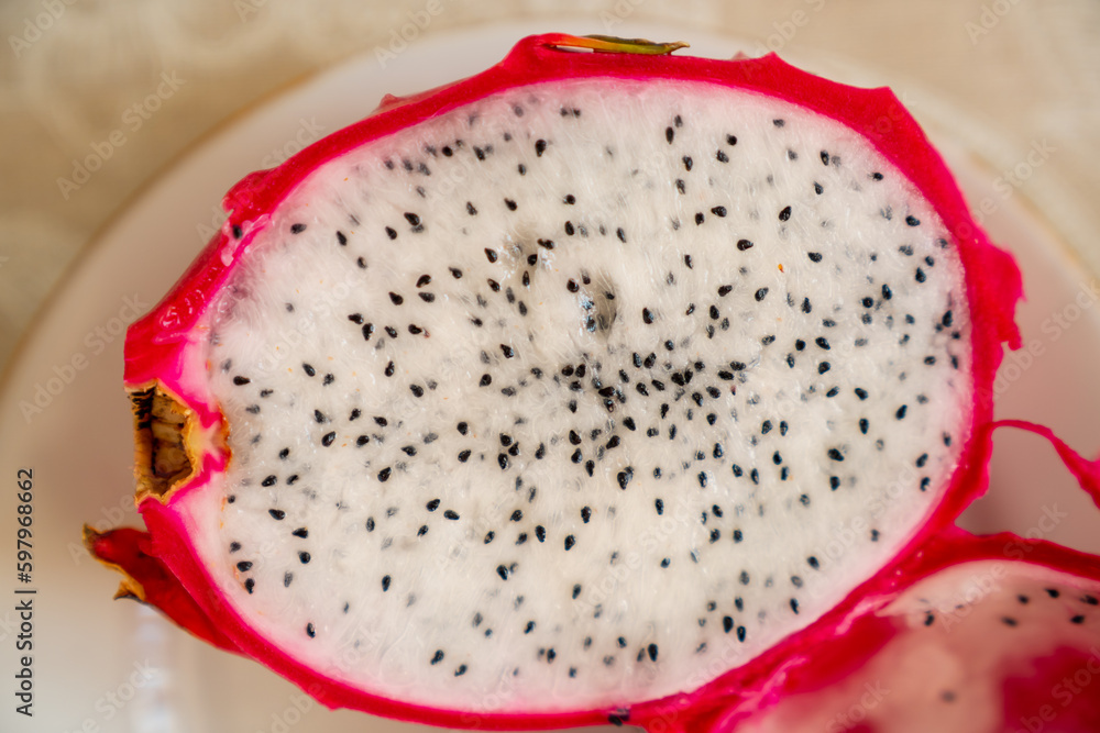 Pitaya (dragon fruit) cut in half with finer and black seeds showing Pitaya (dragon fruit) cut in half with finer and black seeds showing