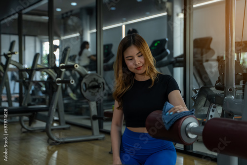 girl in sportswear Checking and cleaning equipment in gym, fitness, sport, workout concept © Surachai
