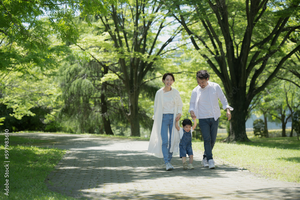 A friendly family taking a walk Image of a family holding hands in the fresh green A friendly family taking a walk Image of a family holding hands in the fresh green