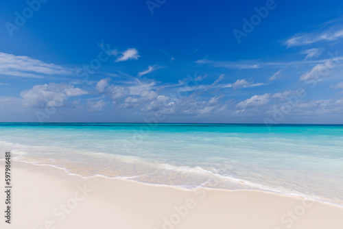Empty tropical island beach seascape horizon. Closeup of sand waves splash under blue summer sky. Carefree beach landscape. Sunny bright sky, soft sand calm tranquil relax sunlight, summer beach mood
