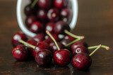 freshly picked cherries in a ceramic mug on a wooden table