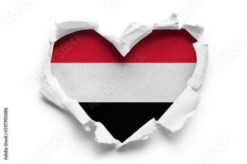 Heart shaped hole torn through paper, showing satin texture of flag of Yemen, cut out photo