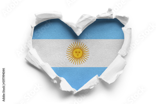 Heart shaped hole torn through paper, showing satin texture of flag of Argentina, cut out