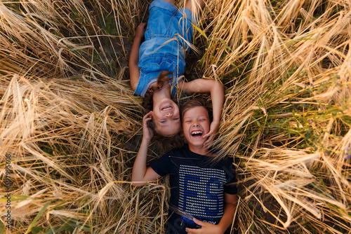 Children on round bales, mowed wheat, bales of wheat, children in Ukraine, wheat field, children in a wheat field with a beautiful sky, bales