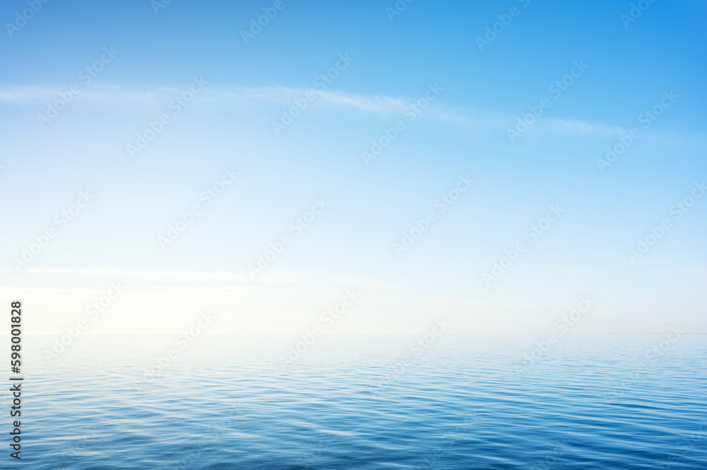 Blue sky over sea or ocean water surface Blue sky over sea or ocean water surface
