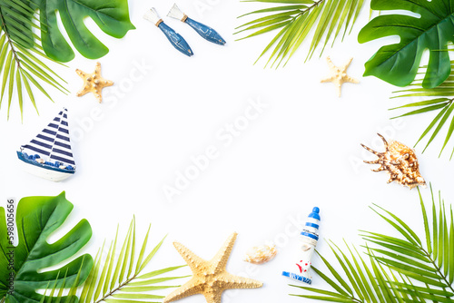 Summer flat lay background. Summer vacation and travel concept. Palm leaves, sea shells and decor on white background.