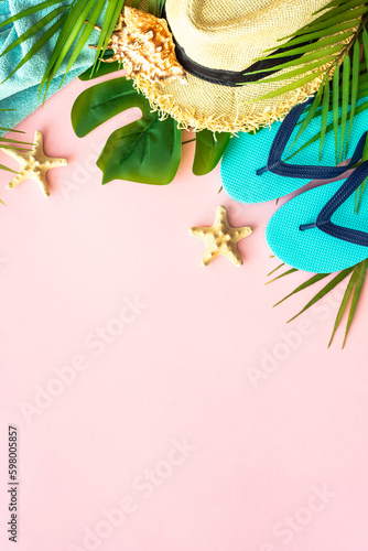 Summer vacation and travel concept. Palm leaves, sea shells and hat on pink background. Flat lay with copy space.