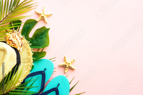 Summer holidays and travel flat lay background. Palm leaves, sea shells and summer cloth on pink background.