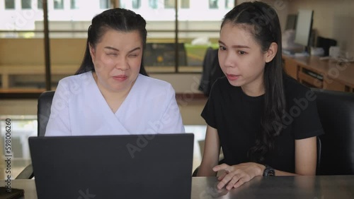 Asian women co-workers in workplace including person with blindness disability using laptop computer with screen reader program for visual impairment people. Disability inclusion at work. photo