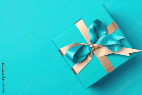 Gift box with satin ribbon and bow on blue background. Holiday gift with copy space. Birthday or Christmas present  flat lay  top view. Christmas giftbox concept